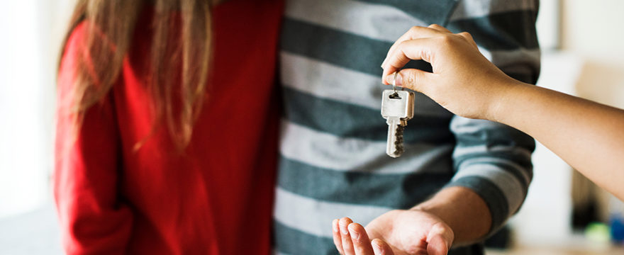 Couple being handed keys in a house